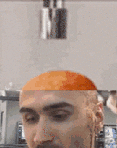 a close up of a man 's face with a red nail polish on