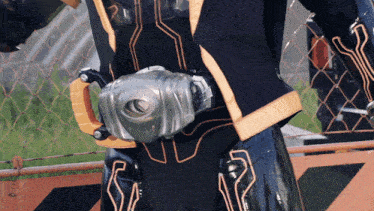 a person in a black and gold costume with a sword