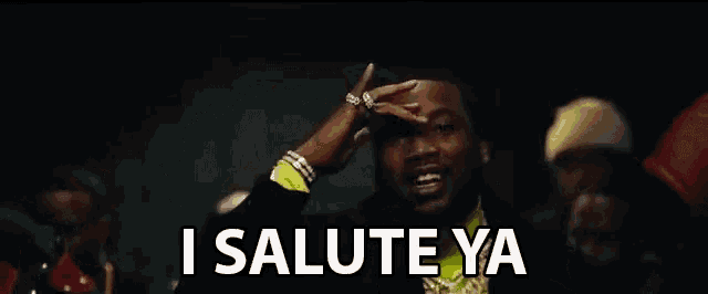 a man is standing in front of a group of people and saying i salute ya .
