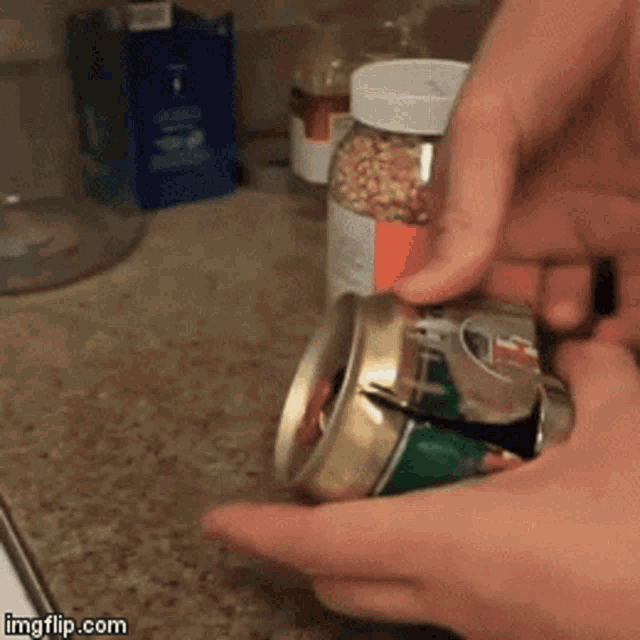 a person is cutting a can with a pair of scissors on a kitchen counter .. imgflip.com