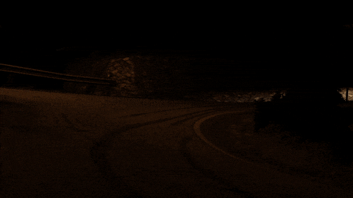 a car is driving down a road at night