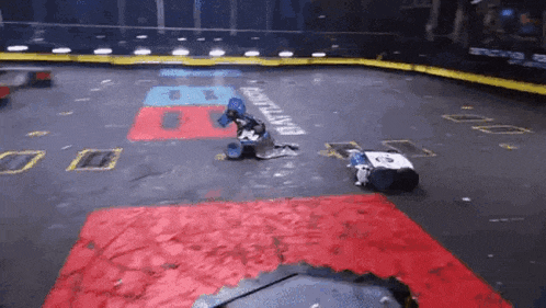 a couple of robots are playing a game on a dirty track .