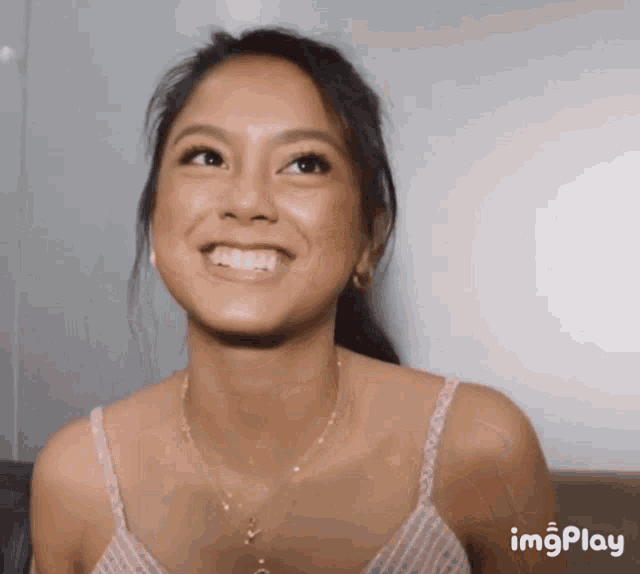 a woman in a pink tank top is smiling with imgplay written on the bottom right
