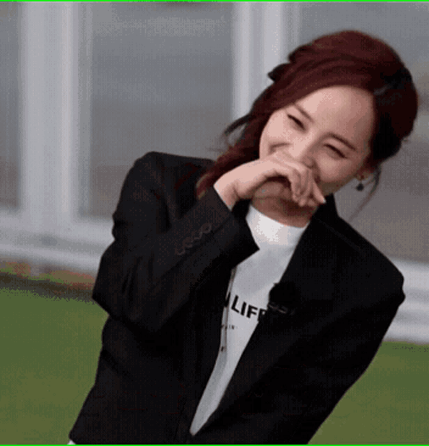 a woman wearing a black jacket and a white t-shirt that says life
