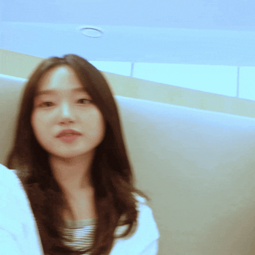 a blurry picture of a woman 's face with a ceiling light in the background