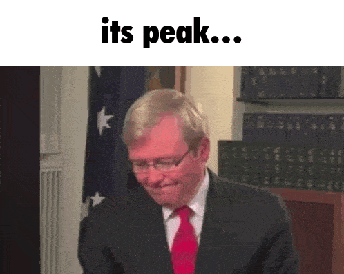 a man in a suit and tie is smiling with the words it 's peak below him