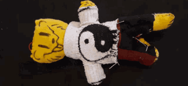a stuffed animal with a snoopy face on it is laying on its back