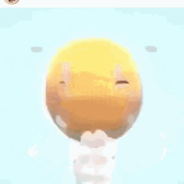 a yellow smiley face with its mouth open is flying in the air .