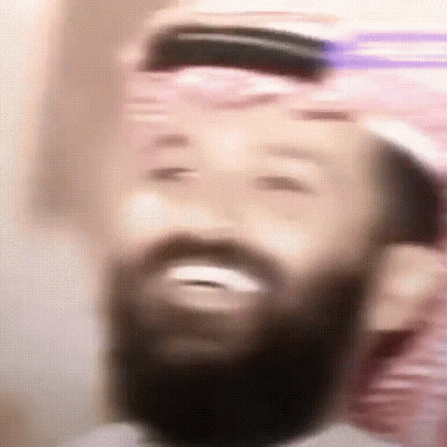 a man with a beard is smiling and wearing a turban