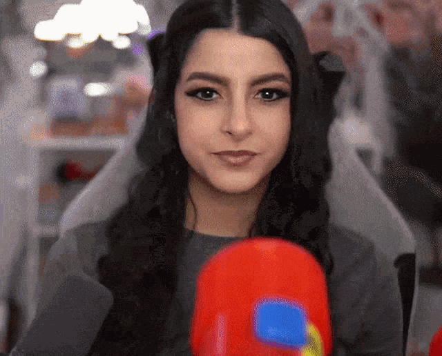 a woman wearing boxing gloves looks at the camera and smiles