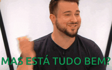 a man with a beard is smiling with the words mas esta tudo bem below him