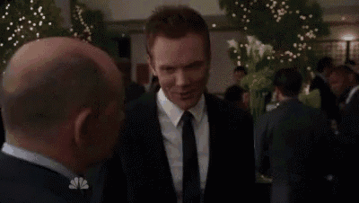 a man in a suit and tie talks to another man