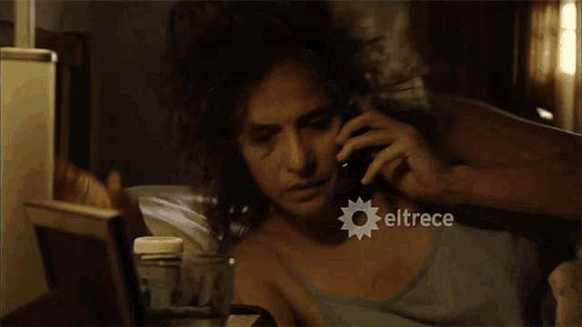 a woman talking on a phone with eltrece written on the bottom right