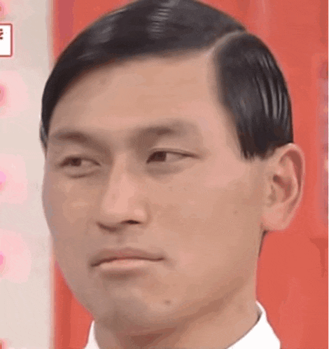 a close up of a man 's face with a slight smile .