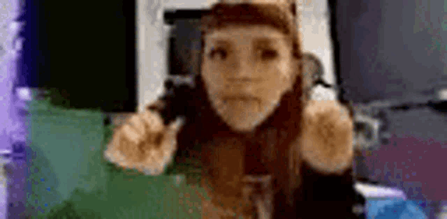 a woman in a cat costume is giving a thumbs up while looking at the camera .