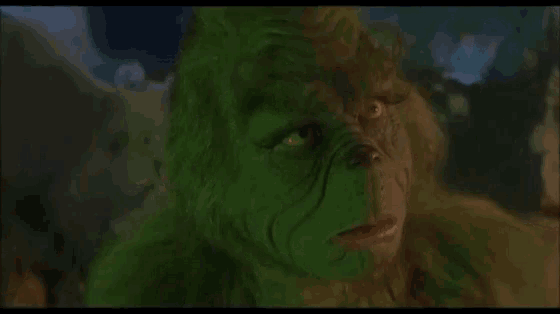 a close up of a grinch 's face with a green furry face .