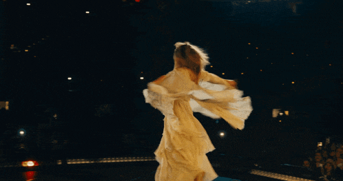 a woman in a white dress is dancing on stage
