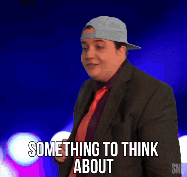 a man in a suit says something to think about while wearing a hat