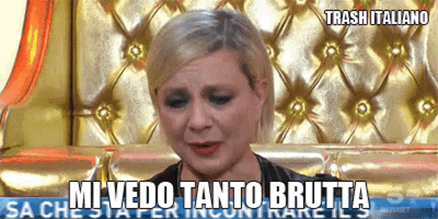 a woman is crying in front of a gold couch and the words mi vedo tanto brutta are above her