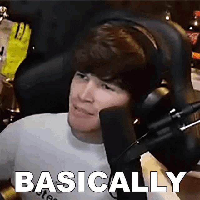 a man wearing headphones is sitting in front of a microphone with the words basically written below him