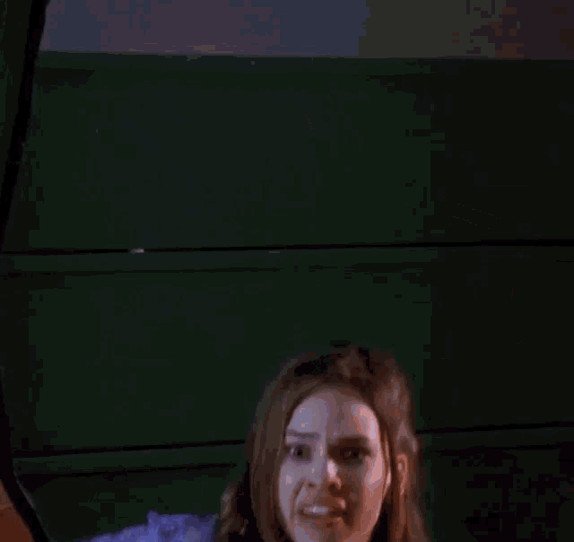 a woman in a purple top and purple jacket is holding a piece of paper