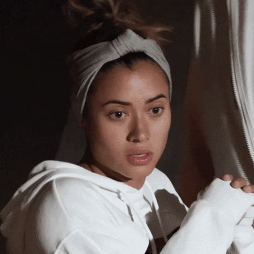 a woman wearing a headband and a white sweatshirt