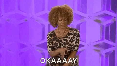 a woman in a leopard print dress is sitting in front of a purple background and saying okay .