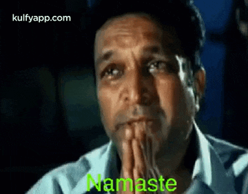 a man is praying with his hands folded in front of his face and the word namaste is on the screen .