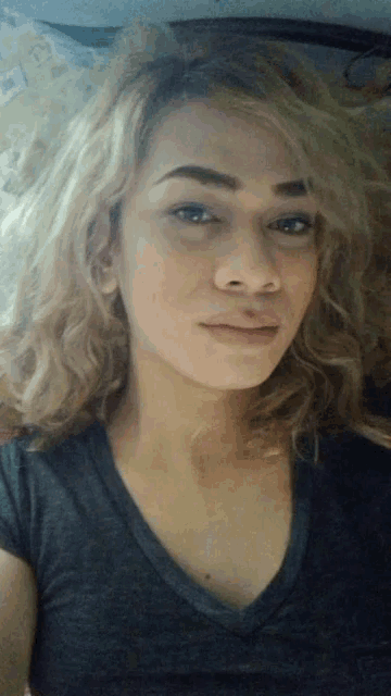 a close up of a woman 's face with a gray shirt on