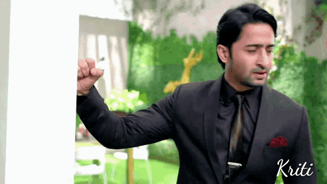 a man in a suit and tie with the name kriti on the bottom