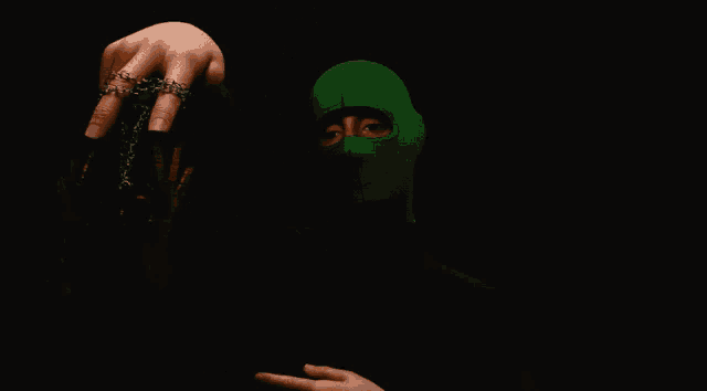 a person wearing a green mask is holding a gold object