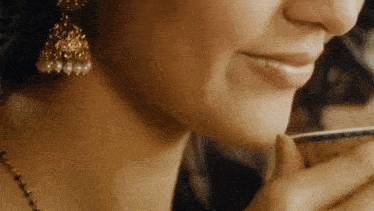 a close up of a woman drinking from a cup of tea .