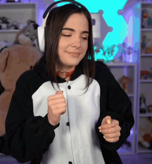 a young woman wearing headphones and a panda costume is dancing