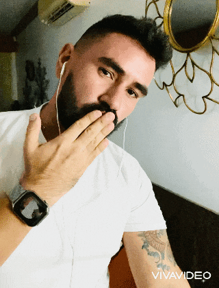 a man with a beard wearing a watch and ear buds