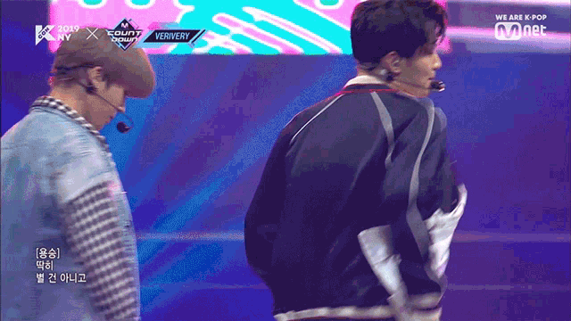 two men are on a stage with a sign that says ververy on it