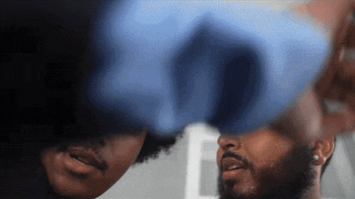 a man with a beard is looking at another man in a mirror