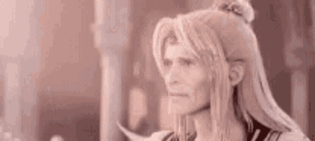 a man with long blonde hair is standing in front of a building .