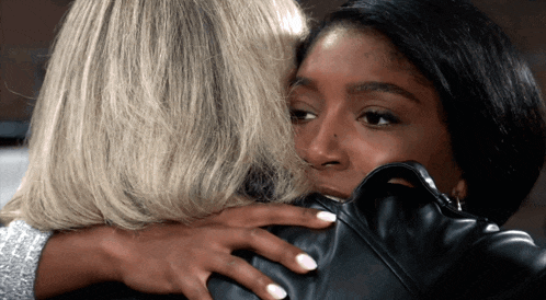 two women are hugging each other and one has a nose ring