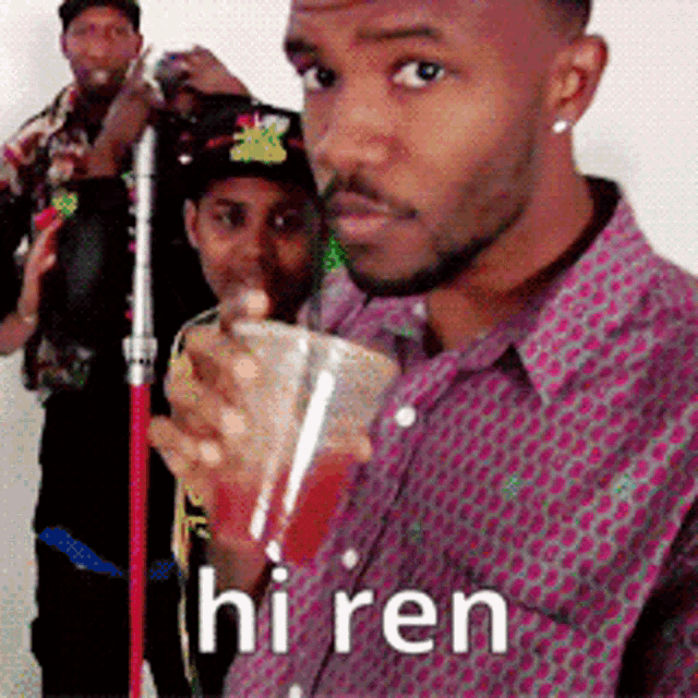 a man in a purple shirt is drinking from a plastic cup with the word hi ren written on it