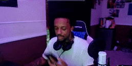 a man wearing headphones is sitting in a chair in front of a microphone .