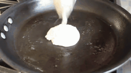 a person is pouring batter into a frying pan