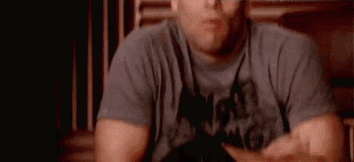 a man is yawning while sitting on a couch .