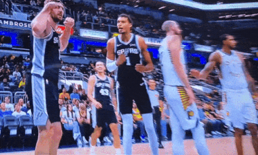 a basketball player wearing a spurs jersey celebrates