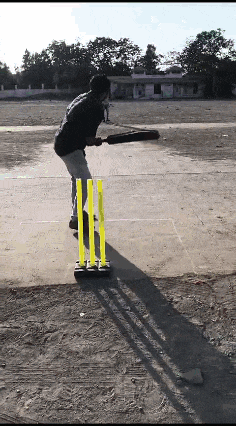 a man is playing a game of cricket on a concrete field