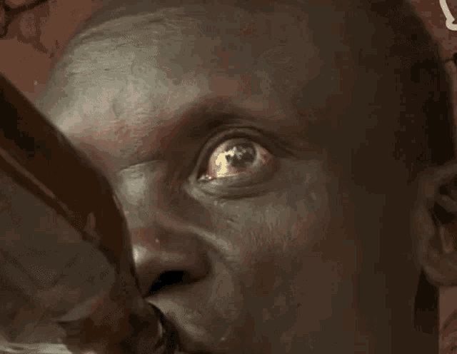 a close up of a man 's face with his eyes wide open making a funny face
