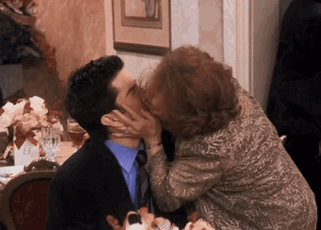 a woman kisses a man on the cheek in front of a table with a number 15 on it