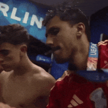 a shirtless man with a medal around his neck that says uefa on it