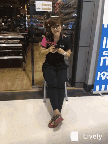 a woman sits on a stool in front of a sign that says ' lively ' on it