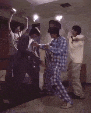 a group of people are dancing in a room while wearing pajamas