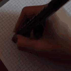 a person writing the letter m on a piece of graph paper